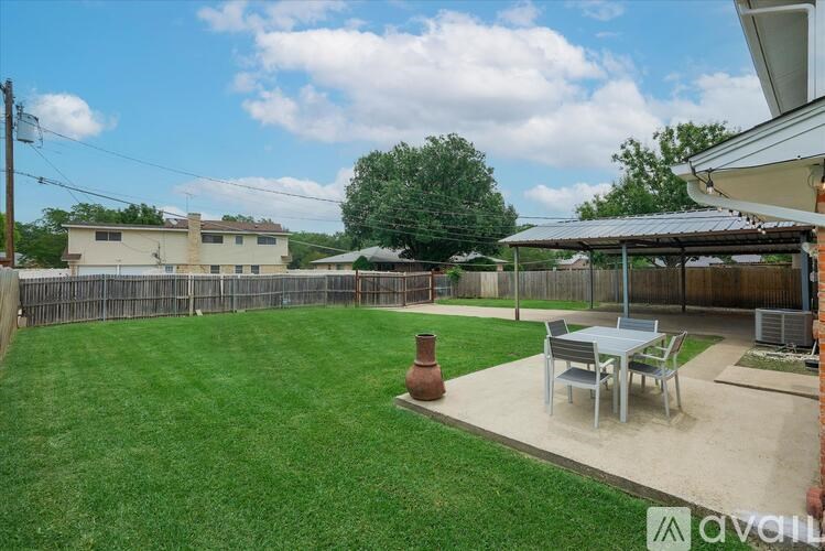 A backyard with a patio table and chairs.