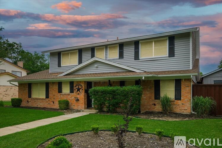 A house with a grey roof and a small garden in front.