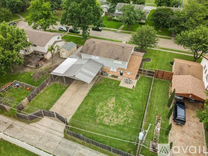 A backyard with a fence and a car.