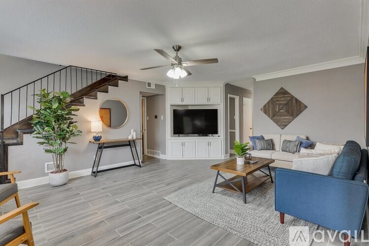 A living room with a staircase and a television.