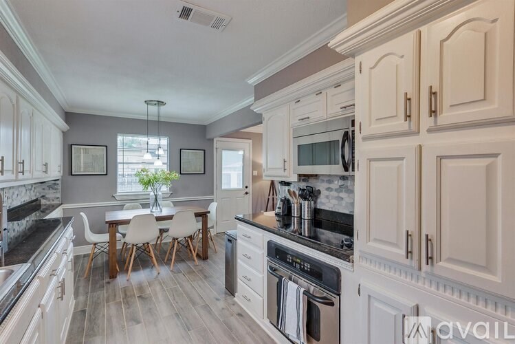 A kitchen with a dining table and chairs.