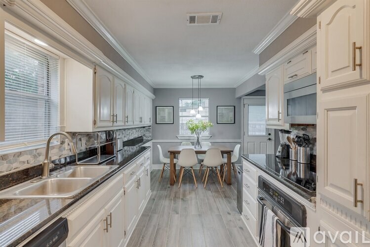 A kitchen with a table and chairs in the middle.