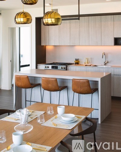A modern kitchen with a dining table set for two.