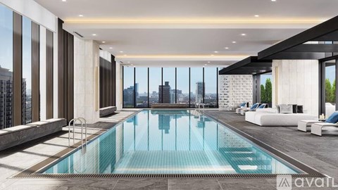 A modern indoor swimming pool with a view of the city.