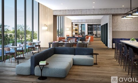 A modern living room with a large grey sofa and a wooden floor.