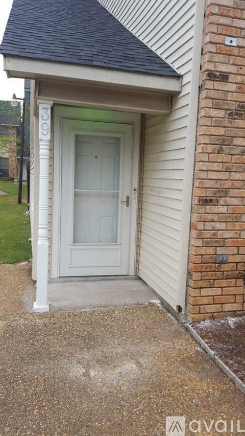 A white door with a glass window is on a house.