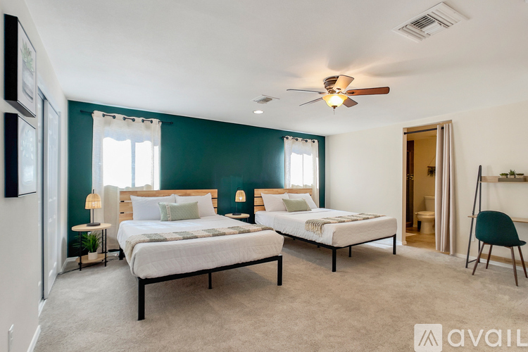 A bedroom with two beds and a ceiling fan.