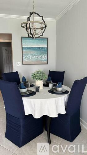 A dining room with a white table and blue chairs.