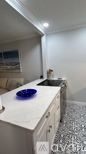 A kitchen with a white counter top and a blue plate on it.