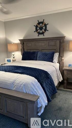 A bedroom with a large bed and a wooden headboard.