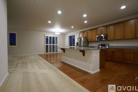 A kitchen with wooden cabinets and a beige rug on the floor.