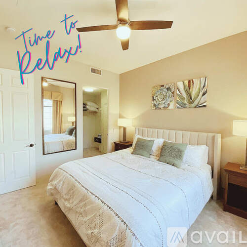 A bedroom with a large bed and a ceiling fan.