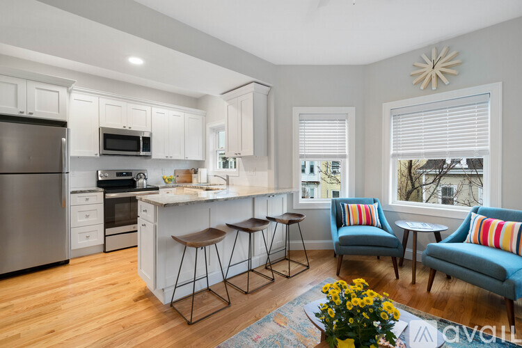 A kitchen with a refrigerator, microwave, oven, and sink.
