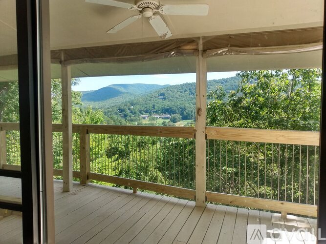 A mountain range is visible through a window with a wooden railing.