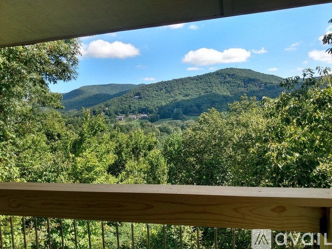 A mountain range is visible through a window with a wooden railing.