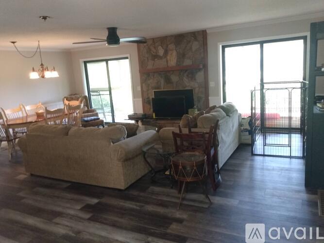 A living room with a couch, chairs, and a television.