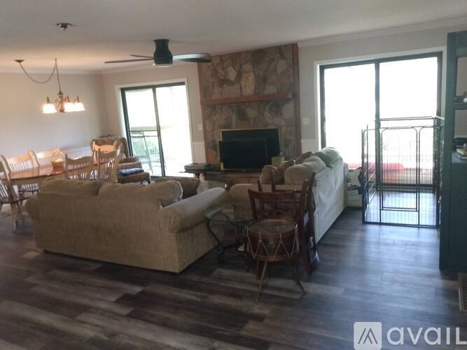 A living room with a couch, chairs, and a television.