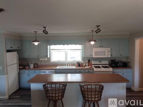 A kitchen with a table and two chairs.
