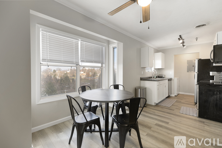 A kitchen with a table and chairs in the foreground and a microwave and oven in the background.