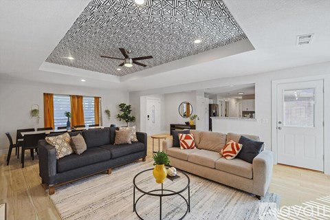 A living room with a grey couch and a black coffee table.