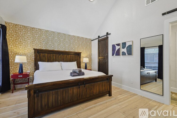 A bedroom with a large bed and a mirror on the wall.