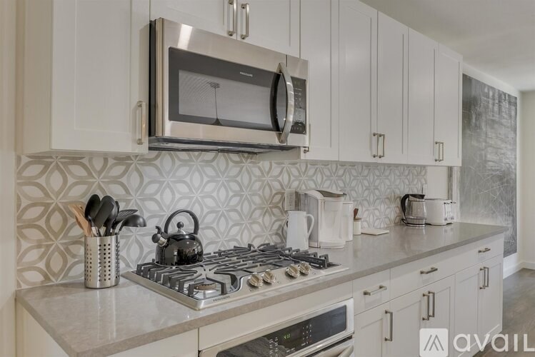 A kitchen with a stove, microwave, and oven.
