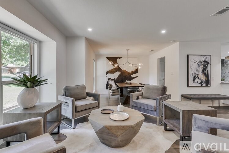 A modern living room with a large coffee table in the center.
