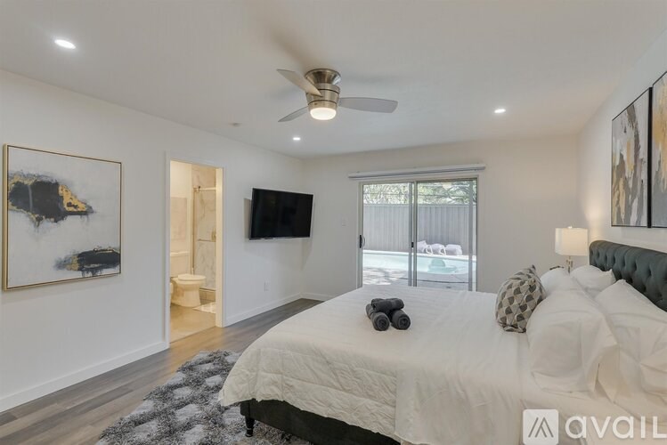 A bedroom with a large bed and a flat screen TV mounted on the wall.