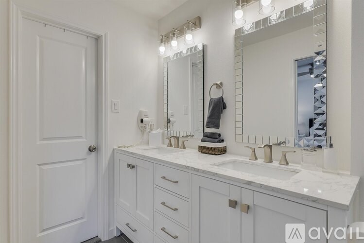 A bathroom with a white vanity and a mirror above it.