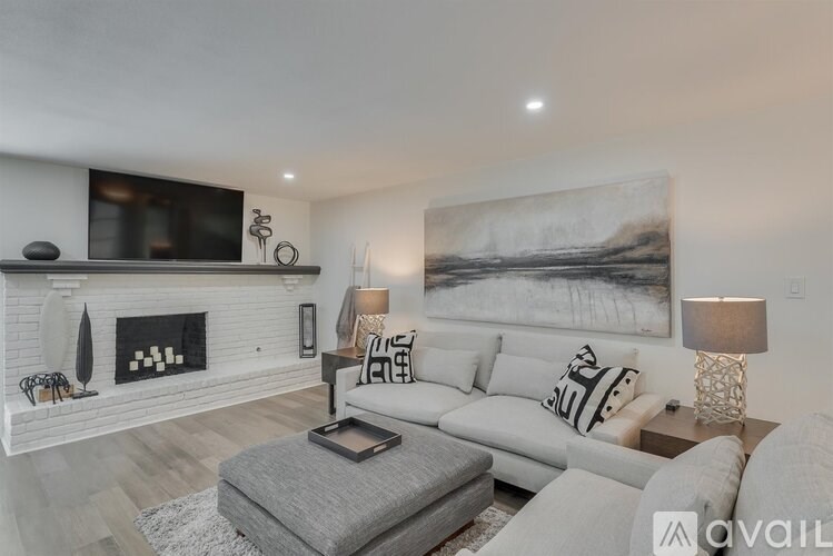 A modern living room with a fireplace and a large painting on the wall.