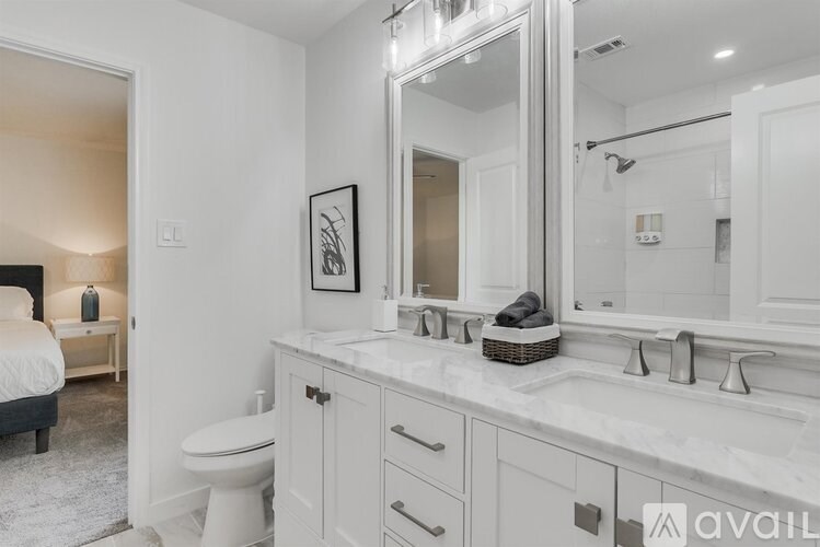 A bathroom with a white toilet and a large mirror above the sink.