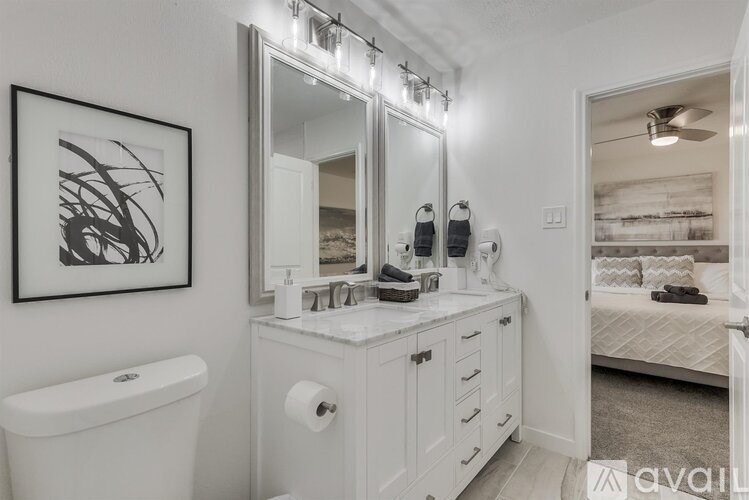 A bathroom with a white tub, sink, and mirror.