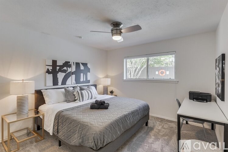 A bedroom with a bed, nightstand, and a ceiling fan.
