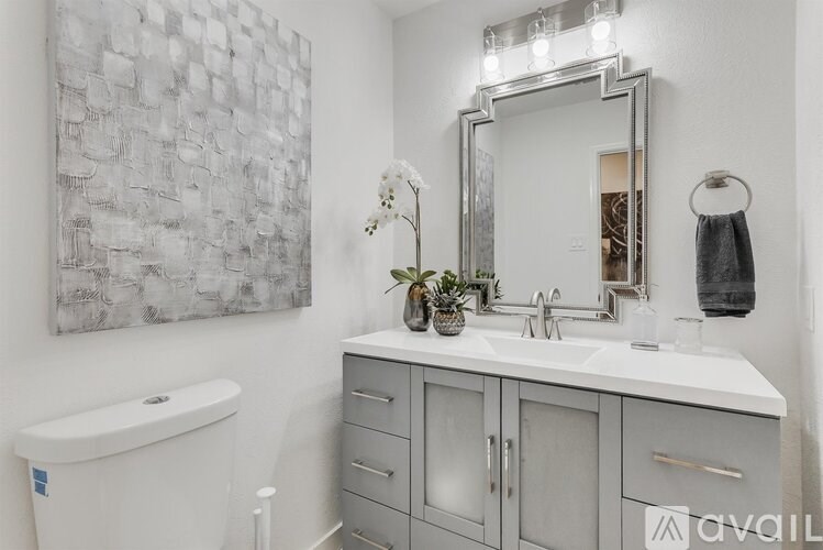 A bathroom with a white tub, sink, and a large mirror.