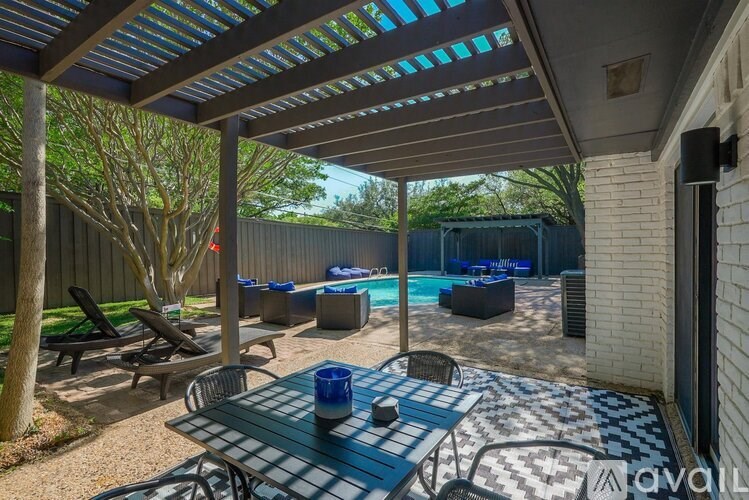 A patio with a table and chairs under a roof.