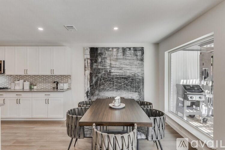 A modern kitchen with a dining table set for six.