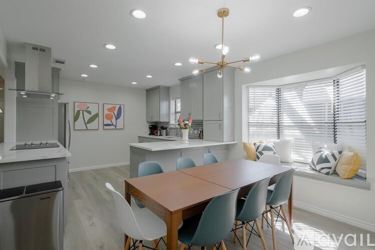A modern kitchen with a dining table and chairs.