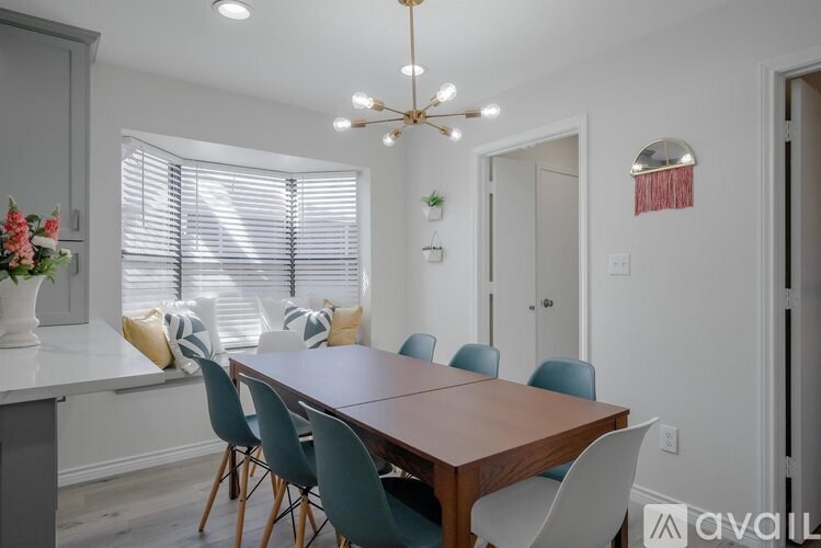 A dining room with a wooden table and chairs.