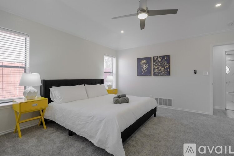A bedroom with a bed, nightstand, and window.