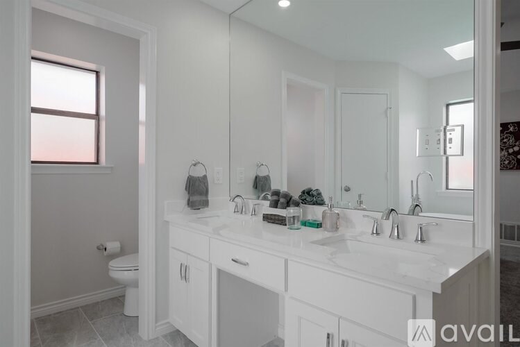 A bathroom with a white vanity and a large mirror.