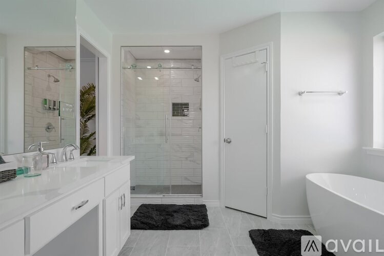 A bathroom with a white tub, sink, and shower.