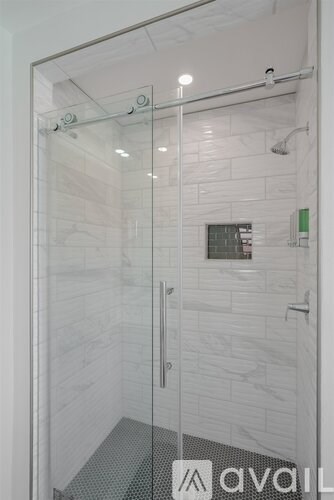 A glass door with a handle and a window on the wall.