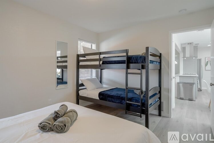 A bedroom with a bunk bed and a white bed.