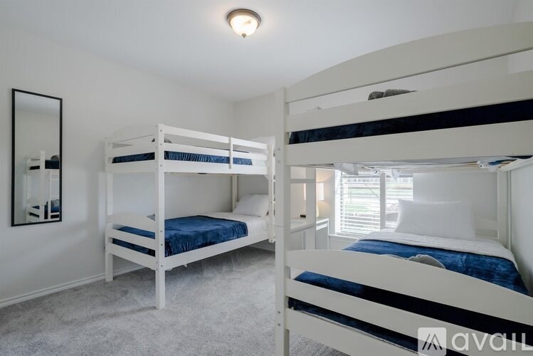 A bedroom with two bunk beds and a mirror on the wall.