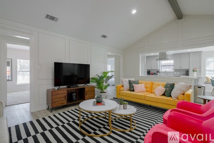 A living room with a black and white striped rug, a yellow sofa, and a television.