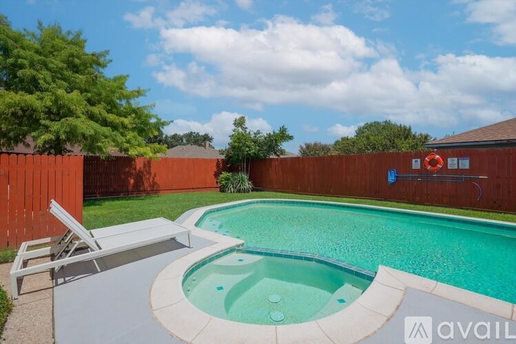 A small pool with a slide and a sun lounger.