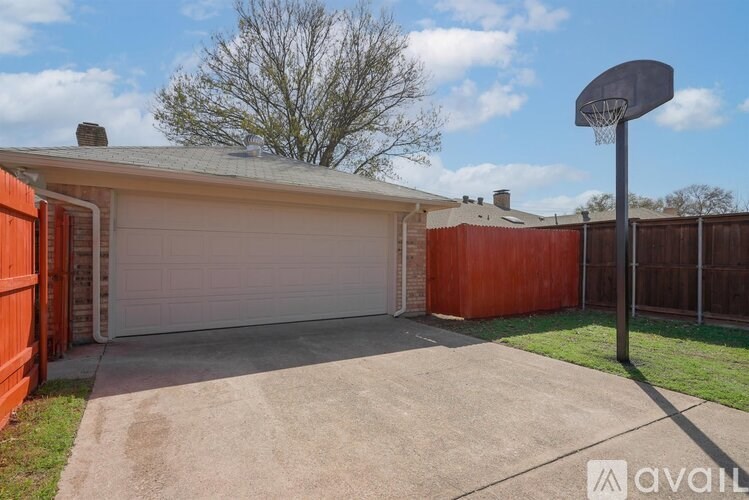 A basketball hoop stands in the middle of a driveway.