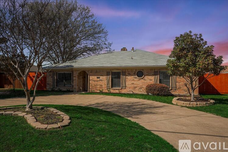A house with a stone facade and a green lawn in front.