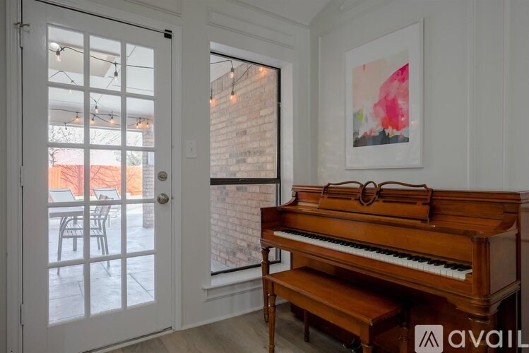 A room with a piano and a painting on the wall.