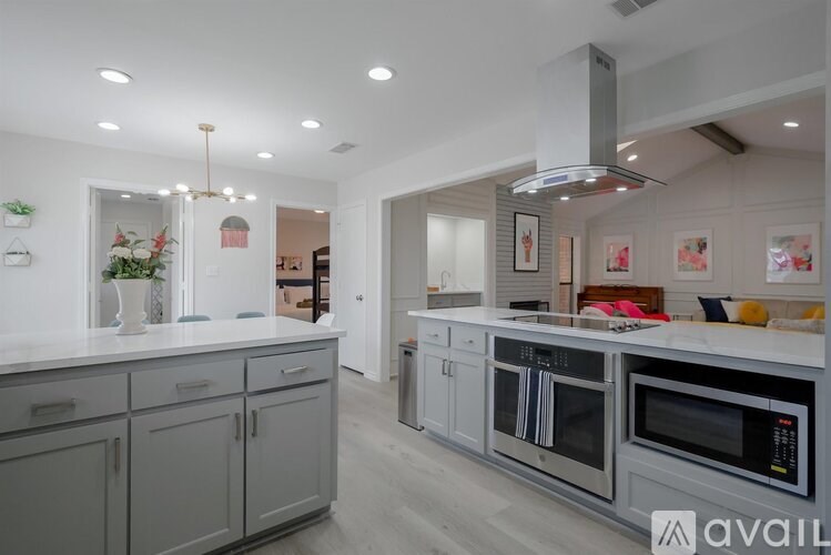 A modern kitchen with grey cabinets and stainless steel appliances.